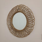 Round woven mirror on a plain wall