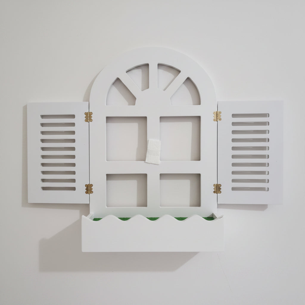 White decorative window frame with shutters on a beige background