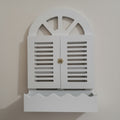 White decorative cabinet with shutter design on a plain background
