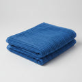 Folded blue towel on a light gray background