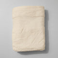 Folded white towel on a pink textured surface