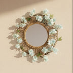 Decorative mirror with floral wreath on a plain wall