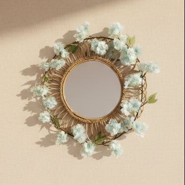 Decorative mirror with floral wreath on a plain wall